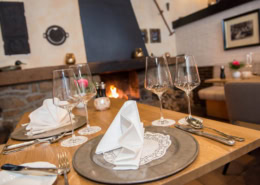 Gemütlicher Restaurant-Tisch im Landhotel Schwallenhof Eleganter Esstisch im Restaurant Zur Feldscheune mit Kerzen, Gläsern und Besteck.